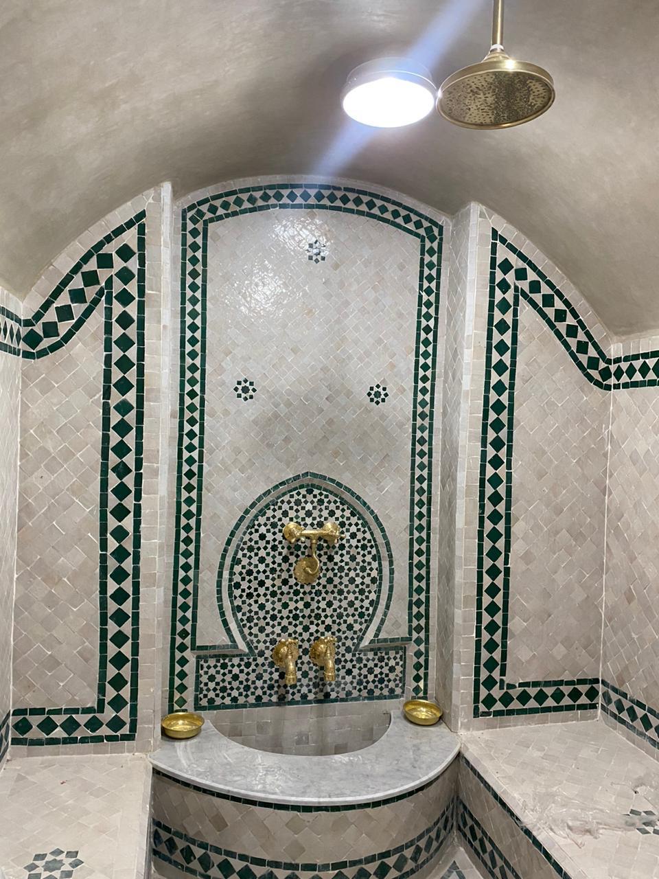 Traditional hammam with hand-cut zellige mosaic and brass fixtures